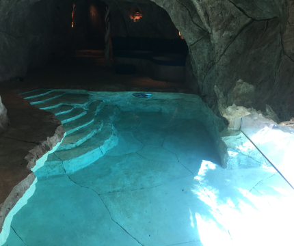 Piscine paysagée dans une grotte en faux rochers
