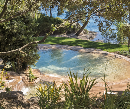 Piscine paysagère avec plage immergée et cascade