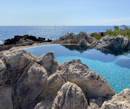 Piscine en faux rochers intégrée dans le décor de bord de mer